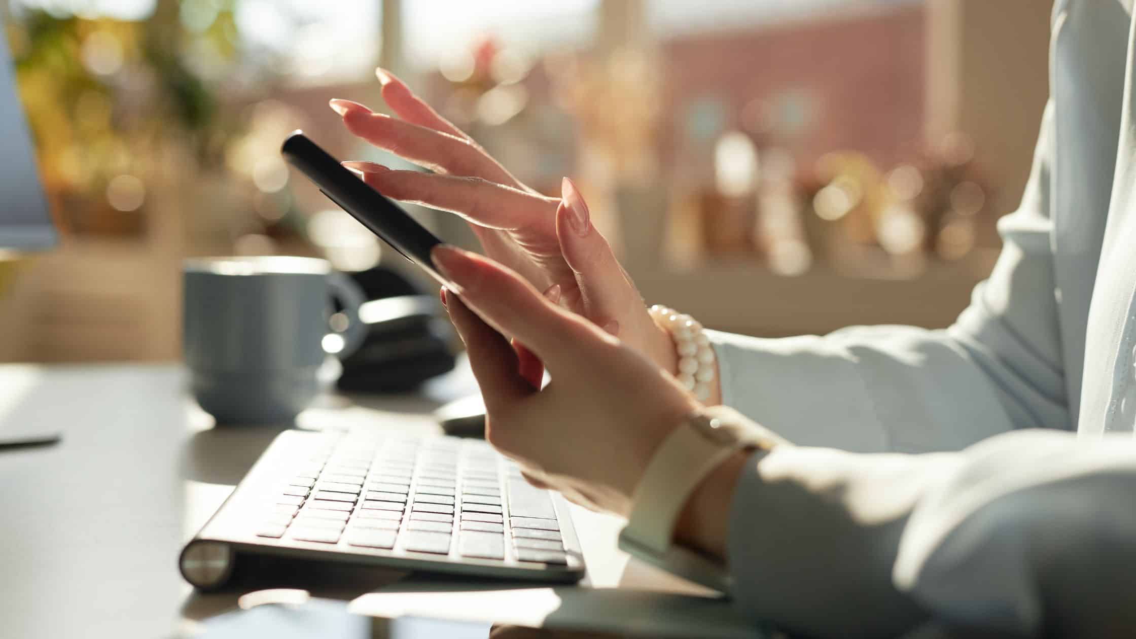 Woman typing on a phone in an office