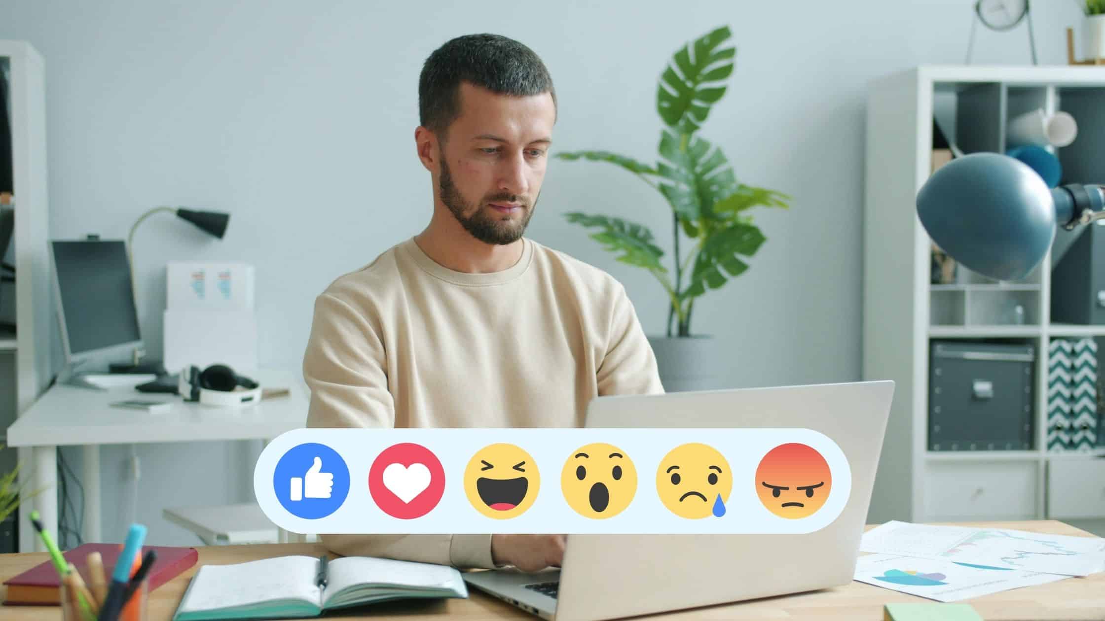 Man sitting in a home office on a laptop with Facebook reactions